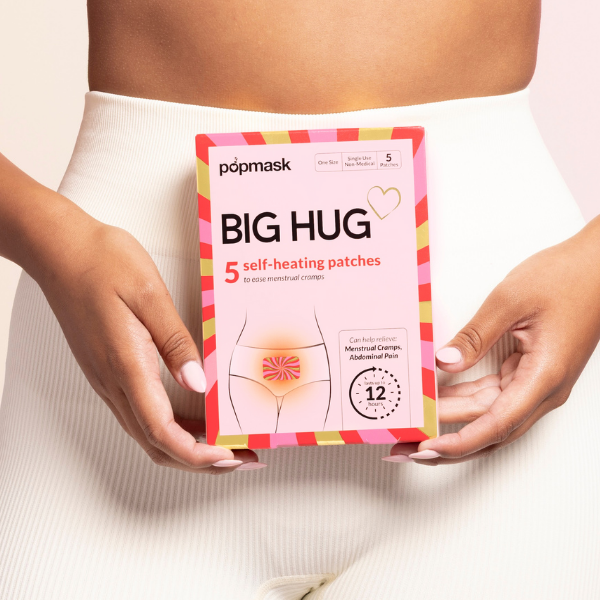 Woman using Popmask Big Hug cramp relief patch on stomach for period pain relief